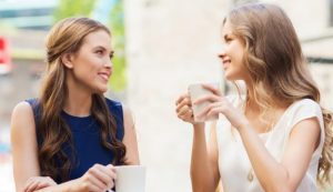 Due giovani donne bevono una cosa al bar